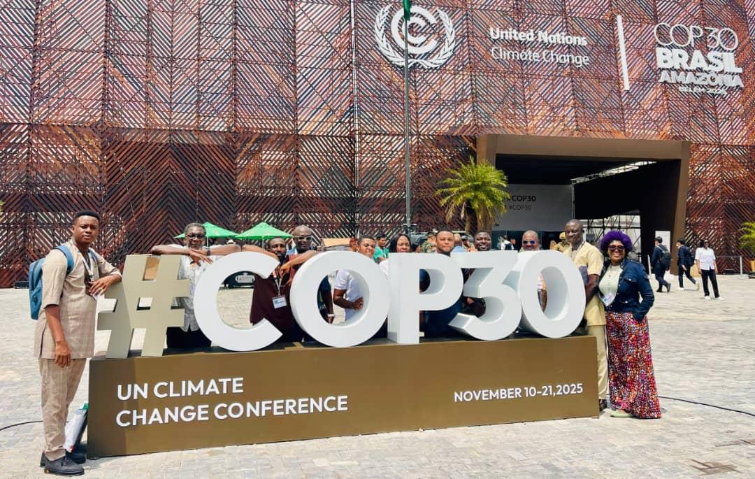 Participants beside the COP30 conference sign